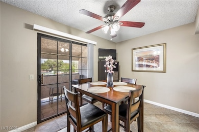 Dining space featuring a textured ceiling and a ceiling fan
