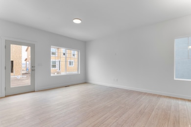 Spare room featuring light wood-type flooring and baseboards