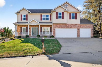 Traditional home with a front yard, covered porch, concrete driveway, and brick siding