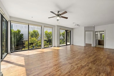 Unfurnished living room with wood-type flooring and ceiling fan