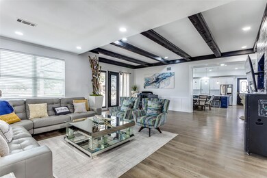 Living room with beamed ceiling and wood-type floo