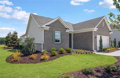 Model RepresentationView of side of property featuring brick siding, roof with shingles, a yard, and an attached garage