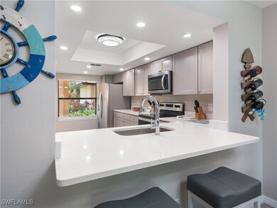 Kitchen with a raised ceiling, a peninsula, applia