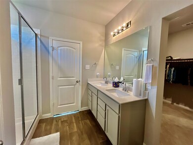 Bathroom with a shower stall, double vanity, wood
