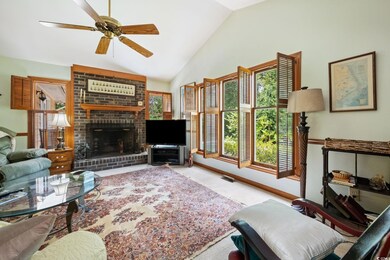 Carpeted living room featuring a fireplace, brick 