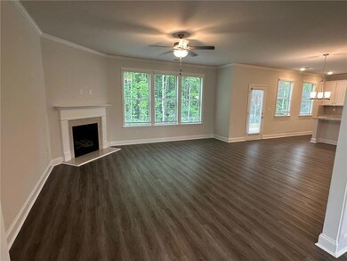 Unfurnished living room with dark wood-style flooring, ornamental molding, a premium fireplace, a ceiling fan, and baseboards