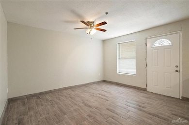 Foyer entrance featuring a textured ceiling, ceiling fan, and hardwood / wood-style flooring