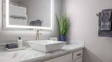 Full bath featuring vanity, a textured wall, and a shower with curtain