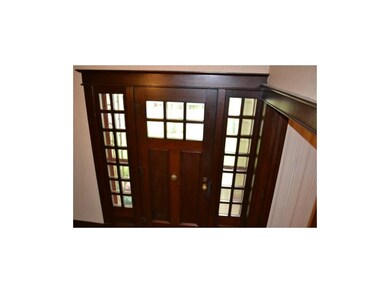 Magnificent walnut front door with beveled glass.
