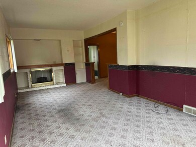 Carpeted empty room featuring a fireplace