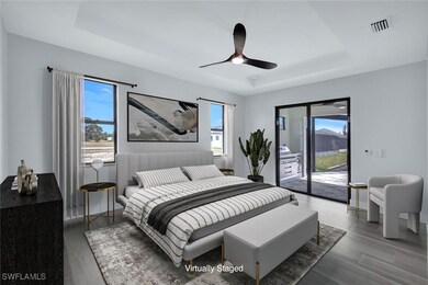Bedroom with a tray ceiling, visible vents, wood f