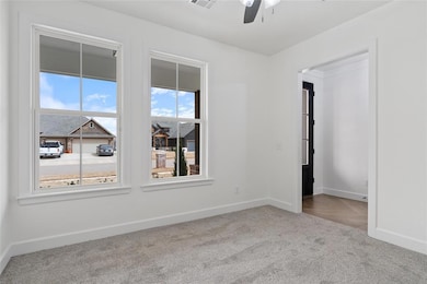 Empty room with carpet flooring, visible vents, ba