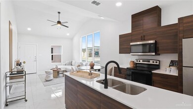 Kitchen featuring lofted ceiling, sink, dark brown cabinets, appliances with stainless steel finishes, and ceiling fan