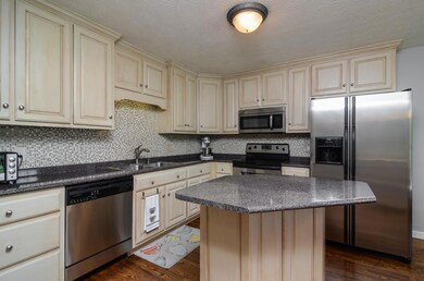 Stainless appliances, antique cabinetry and tile backsplash combine together to make a beautiful kitchen.