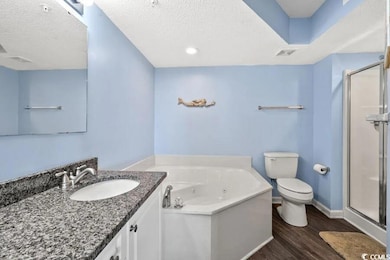 Bathroom with a textured ceiling, toilet, wood fin