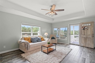 Living room with a tray ceiling, wood finished fl