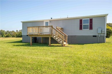 Rear view of house with a yard and wooden deck