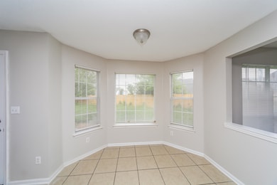 Spare room featuring light tile patterned floors and baseboards