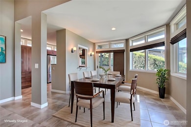 View of the dining room from the family room. Love ALL the windows and patio door leading to your side patio, kitchen off to your left. ***Virtually Staged***