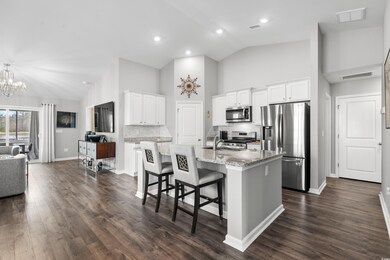 Kitchen featuring a kitchen island with sink, ligh
