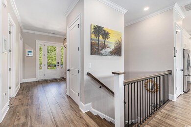 Entryway featuring wood-type flooring, crown molding, baseboards, and recessed lighting