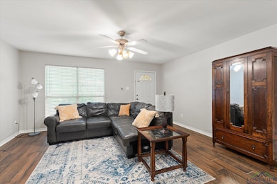 Living room featuring dark wood finished floors and a ceiling fan