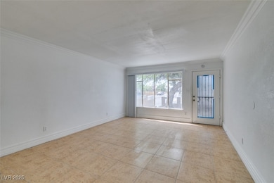 Empty room with crown molding, light tile patterne
