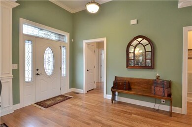 This wide, inviting foyer has a soaring ceiling an