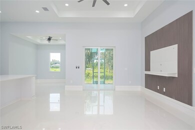 Tiled spare room with ceiling fan and a tray ceili