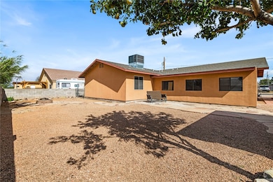 Rear view of property featuring stucco siding, roof with shingles, and a patio