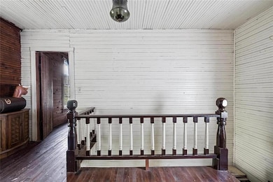 Bedroom featuring wooden walls and dark hardwood /
