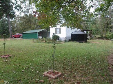 View of grassy yard featuring a detached carport
