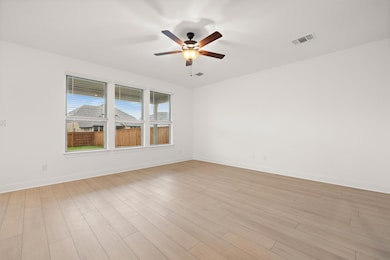 Empty room with a ceiling fan and light wood-styl