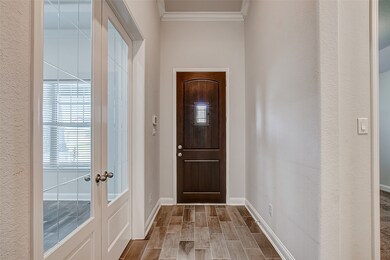 A view of the entryway with the office on the left and a primary bedroom on the right.