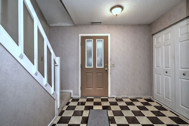 Entry area - closet on right and stairway to second floor.