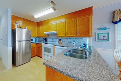 Kitchen with visible vents, a sink, a peninsula, w