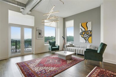 Living area with wood finished floors, a chandelier, and baseboards