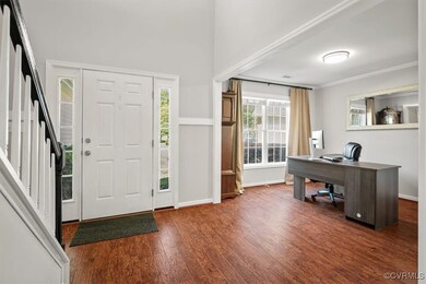 Entryway featuring ornamental molding and dark har