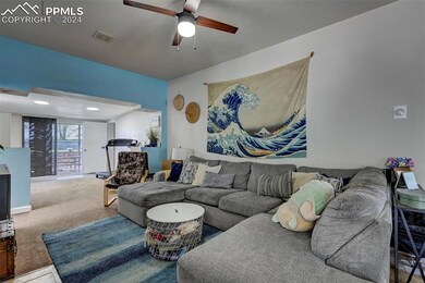 Living room featuring ceiling fan and carpet floor