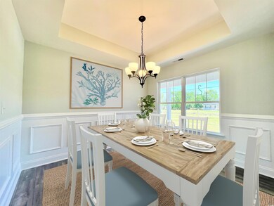 Dining area featuring wood-laminate floors, an inv