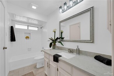 Bathroom featuring toilet, stone finish flooring,  shower combination, and vanity