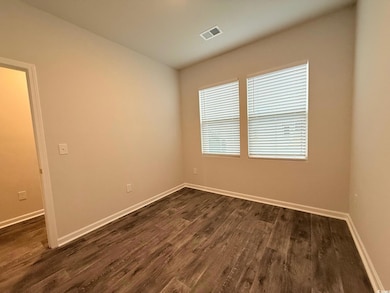 Empty room with visible vents, baseboards, and dar