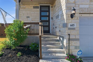 Property entrance featuring stone siding and a garage