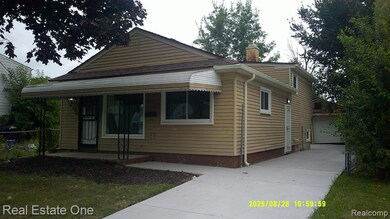 View of front of home with a garage, a chimney, and driveway