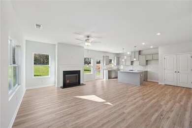 Unfurnished living room featuring plenty of natural light, light wood-style floors, a fireplace, and recessed lighting