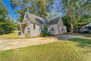 View of front of property with a front yard, driveway, and brick siding