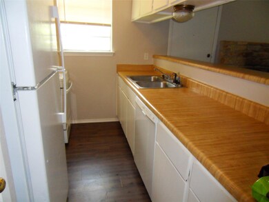 Kitchen with white appliances, a sink, white cabi