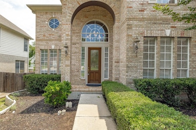 Doorway to property with brick siding and fence