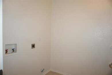 Washroom with light tile patterned flooring, washer hookup, and hookup for an electric dryer