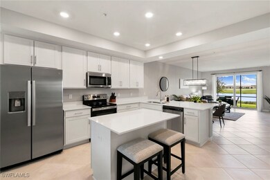 Kitchen with stainless steel appliances, white cabinetry, a breakfast bar, a kitchen island, and recessed lighting